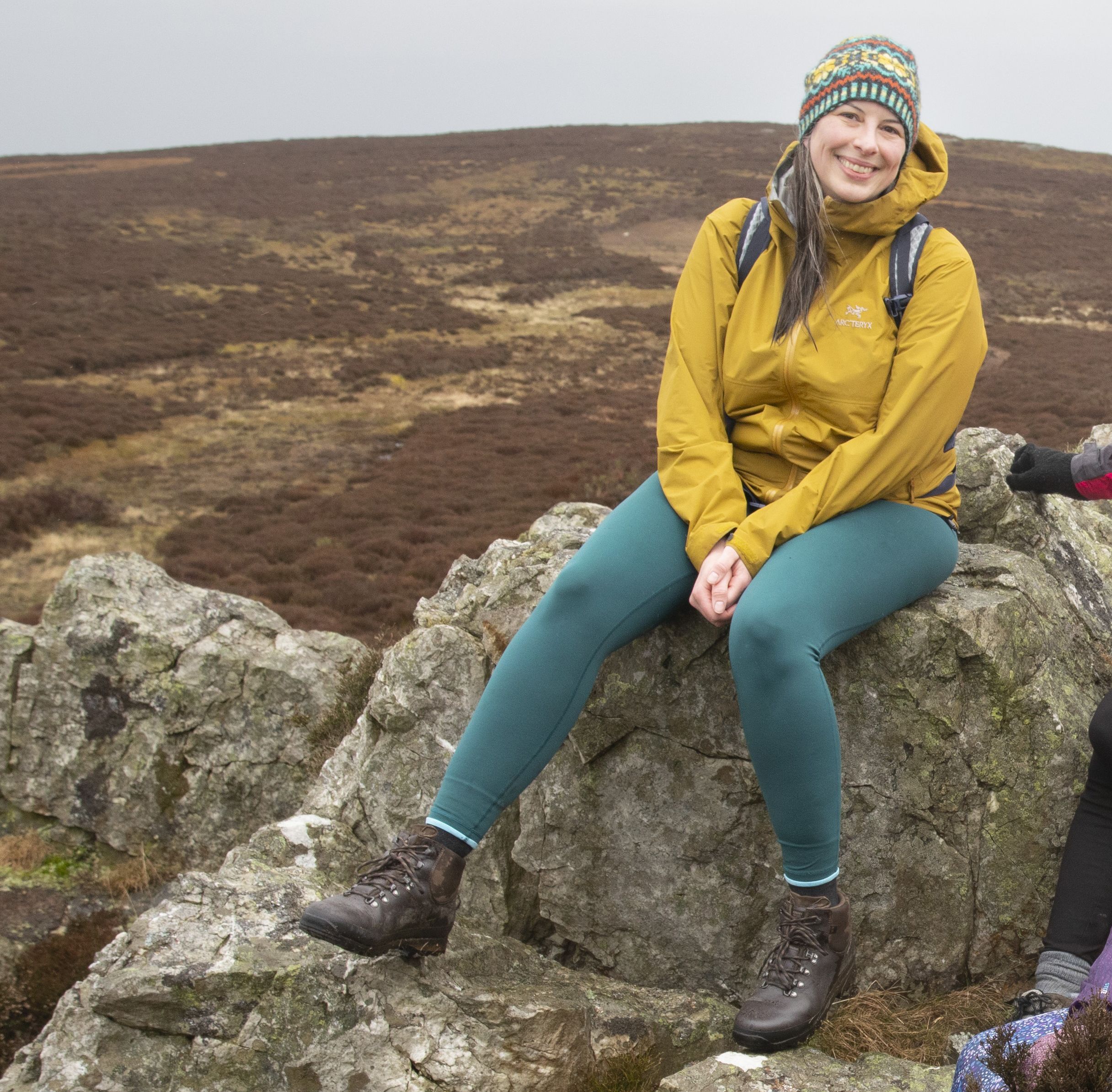 Betsy Maguire, sat on a rock outdoors