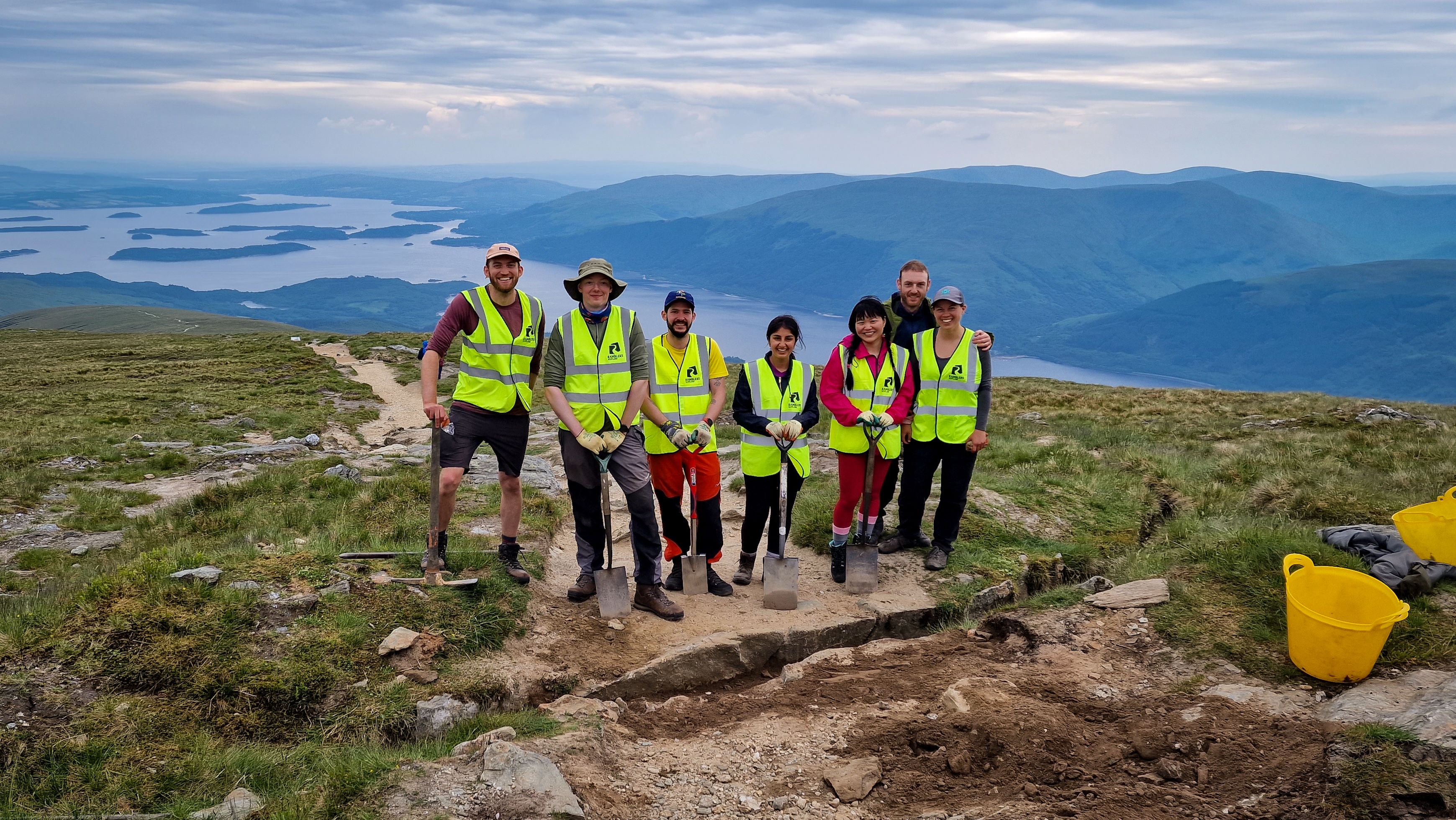 Seven Ramblers volunteers holding shovels in outdoors location