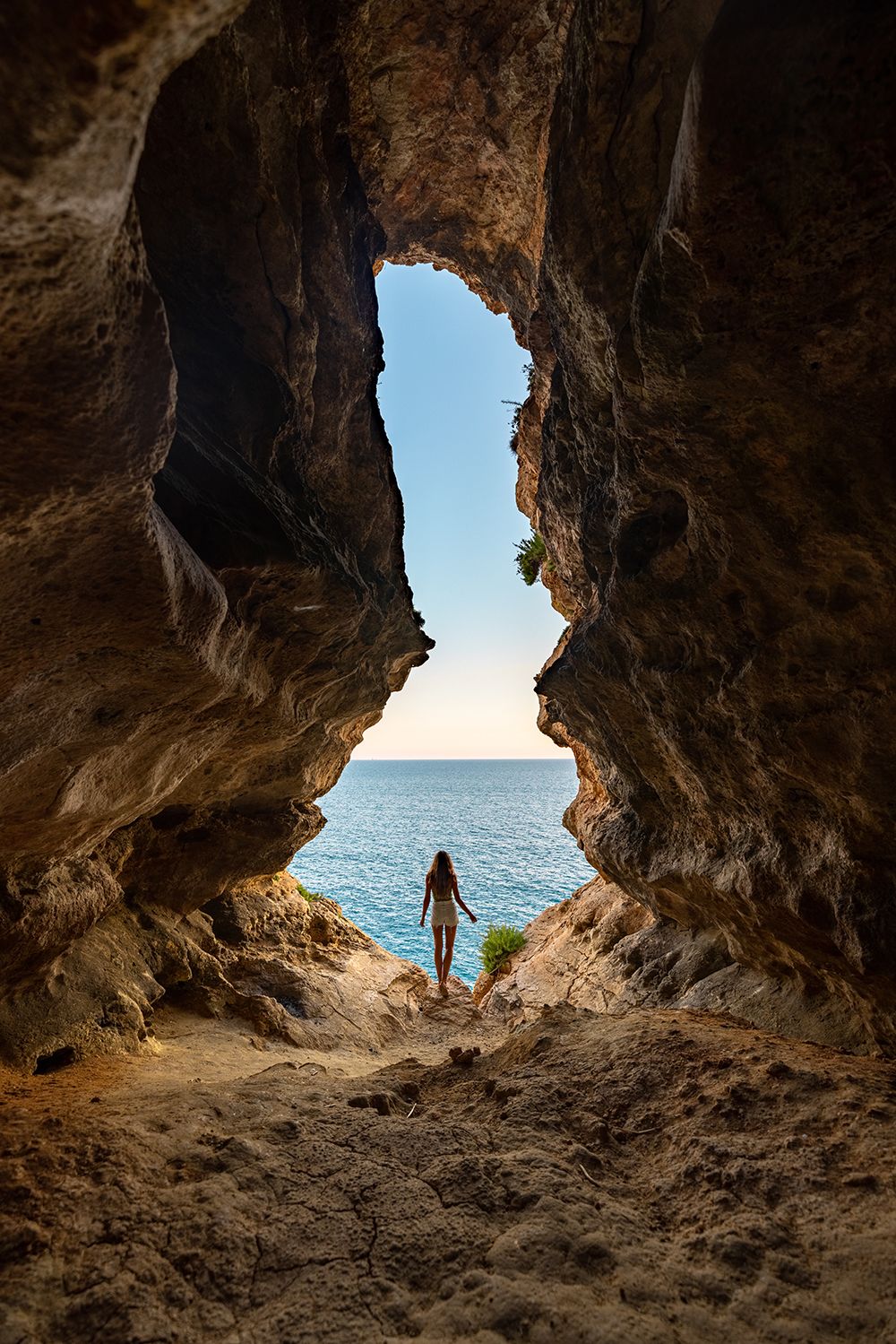 Woman standing in a cave by Malta coast