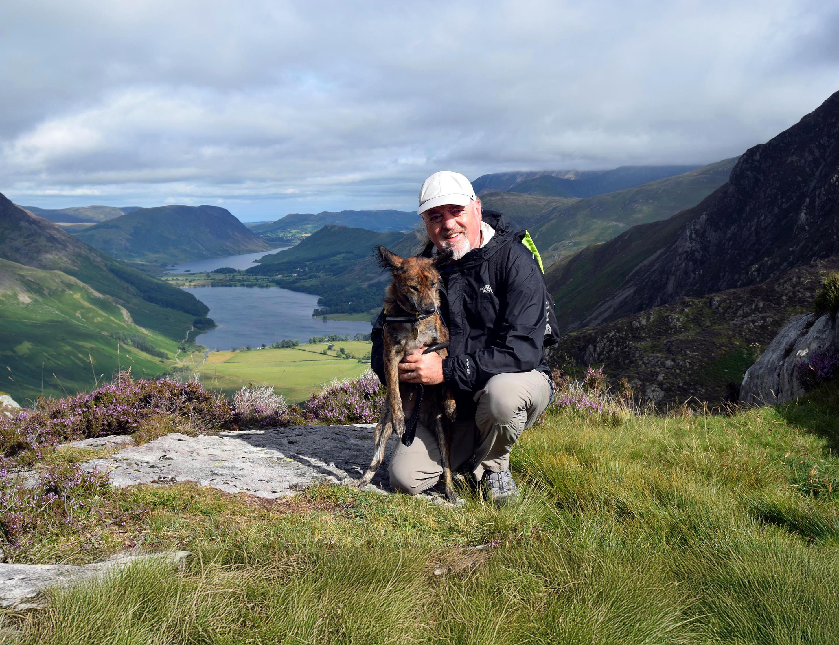 Bill Bailey and his dog in an outdoor location near a lake