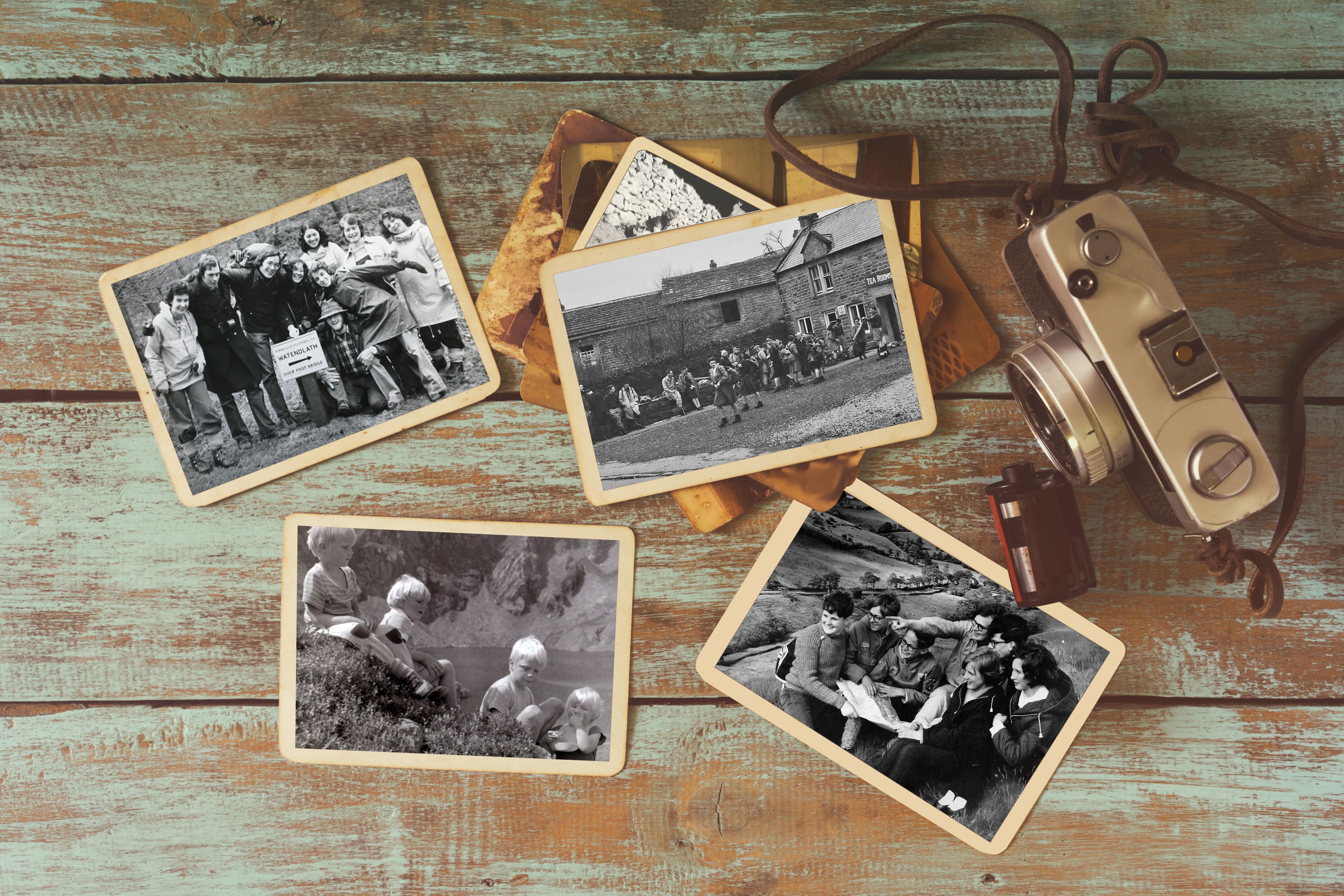 Old photographs and a vintage camera on a wooden table